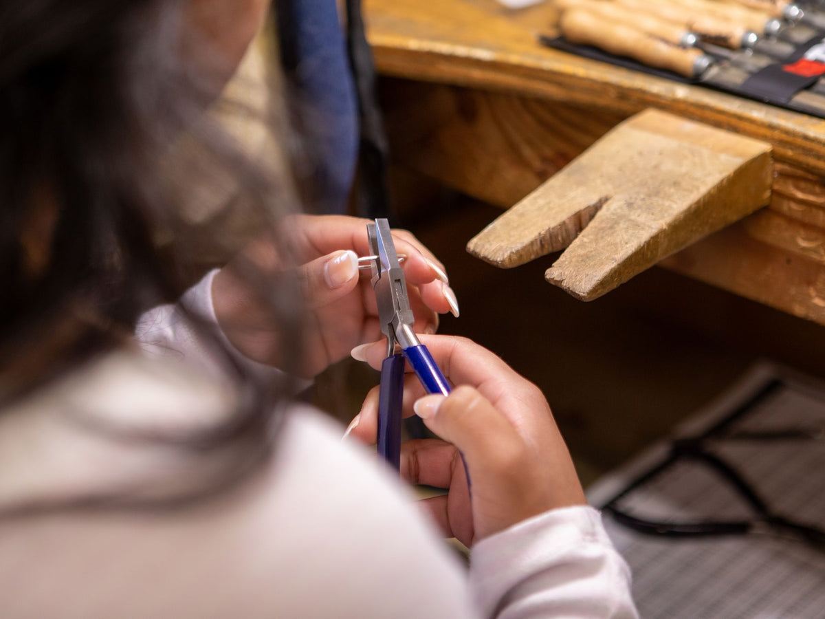Jeweller working on a piece by hand at the bench